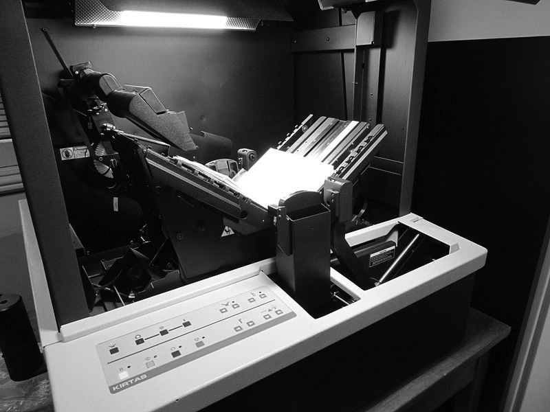 A Kirtas robotic book scanner captures pages with precision. The device features automated mechanisms, enhancing digitization efficiency.